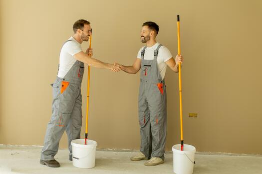 two-workers-shake-hands-in-a-room-after-painting-tasks-are-completed-photo